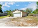 An angled view of this home with a two-car garage and a large driveway with lots of space at 6495 Fall St, St Cloud, FL 34771