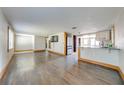 Open concept living space with wood floors and views into the kitchen with an abundance of natural light at 815 Kentucky Ave, St Cloud, FL 34769