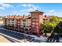 Beautiful architecture featuring brick accents, balconies, palm trees and lush green trees surrounding the perimeter at 911 N Orange Ave # 550, Orlando, FL 32801