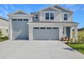 Charming home featuring an attached two-car garage, fresh landscaping, and a welcoming front entrance at 1107 Olivine Ave, Dundee, FL 33838