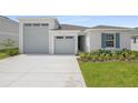 A beautifully landscaped single Gathering home featuring an attached two-car garage and a well manicured lawn at 1122 Olivine Ave, Dundee, FL 33838