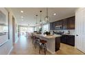 Modern kitchen with center island, pendant lighting, dark cabinets and stainless steel appliances at 1134 Olivine Ave, Dundee, FL 33838