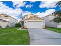 Charming two-story home featuring a two-car garage, neat landscaping, and a welcoming driveway at 133 Rona Ln, Davenport, FL 33897