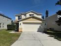 Charming two-story home with two-car garage and well-manicured lawn at 133 Rona Ln, Davenport, FL 33897