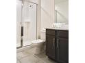 Bathroom featuring a glass-enclosed shower, dark wood vanity, and neutral tile flooring at 1672 Tropical Palms Cir, Kissimmee, FL 34747