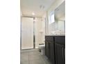 Bathroom featuring glass enclosed shower, dark wood vanity, with modern fixtures and neutral tile flooring at 1672 Tropical Palms Cir, Kissimmee, FL 34747