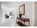 Inviting entryway with tile flooring, a console table, and decor leading into a spacious living area at 2173 Victoria Dr, Davenport, FL 33837