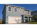 Attractive two-story blue home with a white garage door and well-kept landscaping at 2532 Ryland Falls Dr, Lakeland, FL 33811