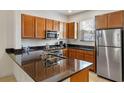 Modern kitchen features granite countertops, stainless steel appliances, and wooden cabinetry at 2621 Corvette Lane, Kissimmee, FL 34746