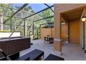 Outdoor patio featuring a screened-in enclosure, hot tub, and dining area at 2621 Corvette Lane, Kissimmee, FL 34746