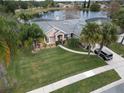 Charming single-Gathering home featuring a well-manicured lawn and mature palm trees by a lake at 2631 Eagles Nest Ct, Orlando, FL 32837