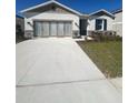 Modern home showcasing a wide driveway, stone accents, and double doors at 280 Hilltop Bloom Loop, Haines City, FL 33844