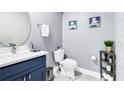 Stylish powder room featuring a modern vanity, round mirror, and contemporary fixtures at 2879 Common Crane Ct, Harmony, FL 34773