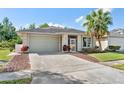 Lovely home showcasing a manicured lawn, mature landscaping, and a spacious driveway at 2958 Sunset Vista Blvd, Kissimmee, FL 34747