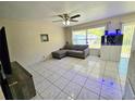 This living room has a ceiling fan and an aquarium with a gray sofa at 3115 Via Uno, Orlando, FL 32817