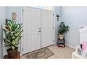 Inviting entryway with double doors, tiled floor, area rug, and decorated with plants and artwork at 417 Spice Ct, Kissimmee, FL 34758