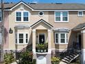 Two-story townhome showcases bay windows, a private balcony, and stylish black and tan exterior paint at 6659 Times Square Ave 38-103 # Orlando, Orlando, FL 32835