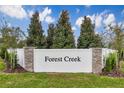 Elegant community entrance sign 'Forest Creek' with stone accents and lush landscaping at 808 Blue Creek Dr, Haines City, FL 33844