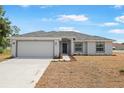 Charming single-story home featuring a two-car garage, fresh landscaping, and a well-manicured lawn at 101 Sail Way, Kissimmee, FL 34759