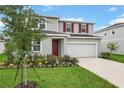 Charming two-story home with a well-manicured lawn and colorful flower beds at 1035 Wisteria Way, Dundee, FL 33838
