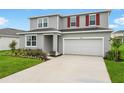 Charming two-story home with a well-manicured lawn and colorful flower beds at 1035 Wisteria Way, Dundee, FL 33838