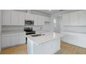 Bright kitchen featuring an island, white cabinetry, stainless steel appliances at 1035 Wisteria Way, Dundee, FL 33838