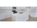 Modern kitchen featuring white cabinets, quartz countertops, and stainless steel appliances at 1039 Wisteria Way, Dundee, FL 33838