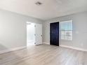 Inviting living room features new gray vinyl floors, fresh paint, leading to other rooms in the home at 1085 Whitewood Dr, Deltona, FL 32725