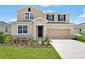 Inviting two-story home with a well-kept lawn, stone accents, and attached two car garage at 1130 Olivine Ave, Dundee, FL 33838
