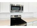 Stainless steel appliances are a highlight of the kitchen, showcasing the microwave and stovetop at 1130 Olivine Ave, Dundee, FL 33838