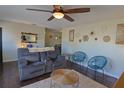 Cozy living room featuring dark wood floors, grey reclining sofa, and decorative wall art at 1215 Little Spring Hill Dr, Ocoee, FL 34761