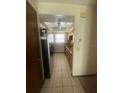 Galley kitchen featuring tile floor, oak cabinets, stainless steel appliances, and a ceiling fan at 1304 Mill Creek Pl, Kissimmee, FL 34744