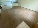 Spacious living room featuring a cozy carpet and tile flooring transitioning into the dining area at 1304 Mill Creek Pl, Kissimmee, FL 34744