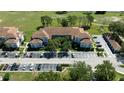 An aerial view of the condo buildings, parking, landscaping, and proximity to grassy lawns and lake at 14049 Fairway Island Dr # 122, Orlando, FL 32837