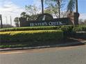 A view of the Hunter's Creek Community entrance sign with a manicured yard at 14049 Fairway Island Dr # 127, Orlando, FL 32837