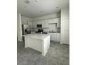 Bright kitchen with white cabinets, quartz countertops, stainless steel appliances, and a center island at 2414 Skyline Loop, Kissimmee, FL 34758