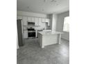 Bright kitchen featuring white cabinets, quartz countertops, stainless steel appliances, and a center island at 2414 Skyline Loop, Kissimmee, FL 34758