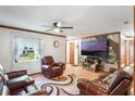 Spacious living room with a ceiling fan, large windows, and comfortable seating arrangement at 2429 Oak Run Blvd, Kissimmee, FL 34744
