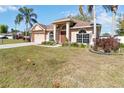 Charming single-story house showcases a lush green lawn, a spacious driveway, and mature palm trees at 2706 Sebastian Ct, Kissimmee, FL 34743