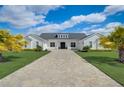 Beautiful modern farmhouse with manicured lawn, brick drive, and palm trees at 3409 Lake Diane Rd, Tavares, FL 32778