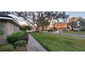 Residential street view showing a home with mature trees and a well-maintained front lawn at 3637 Rothbury Dr, Belle Isle, FL 32812