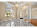 Spacious foyer with marble floors, offering a view of the bright entrance and elegant architectural details at 3637 Rothbury Dr, Belle Isle, FL 32812