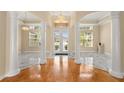 Elegant foyer featuring marble and hardwood floors, complemented by grand columns and abundant natural light at 3637 Rothbury Dr, Belle Isle, FL 32812