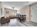 Open-concept living area with gray flooring, a ceiling fan, large window, and stylish furnishings at 4561 Yellowgold E Rd # 107, Kissimmee, FL 34746