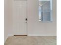 Inviting entryway with light tile floors, a modern front door, and a bright window at 4672 Tribute Trl, Kissimmee, FL 34746