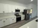 Modern kitchen with stainless steel appliances, white cabinets, quartz countertops, and modern tile backsplash at 4863 Sw 159Th Ln Rd, Ocala, FL 34473