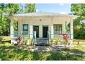 Inviting home with a covered porch, green trim, and a welcoming walkway amidst a manicured lawn at 5641 Orange Ave, Intercession City, FL 33848