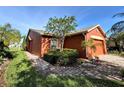Charming single Gathering home with brick paver driveway, lush landscaping, and beautiful curb appeal at 585 Grand Canal Dr, Poinciana, FL 34759