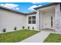 Well-manicured front yard with a walkway leading to a modern-style home featuring stone veneer accents at 780 Kangaroo Ct, Deltona, FL 32738