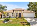 Charming single-story home with a well-manicured lawn and inviting curb appeal on sunny day at 1129 Dartford Dr, Kissimmee, FL 34758